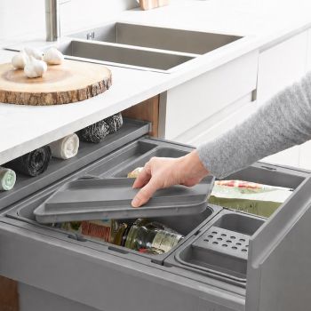 Ninka ECO Individual Lid installed in kitchen drawer  showing pull-out storage with organized compartments for cleaning supplies and kitchen items
